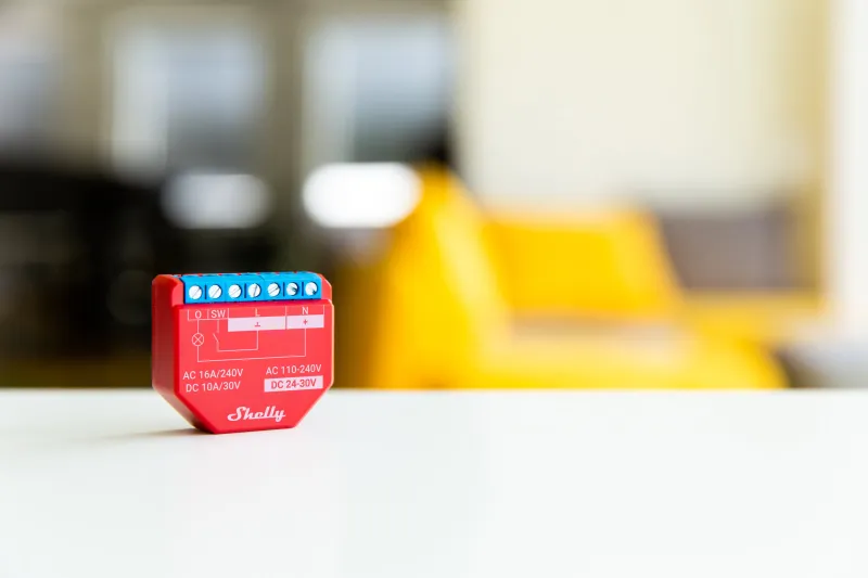 Shelly Plus 1PM in der Hand zum Größenvergleich, kompakt für Standard-Unterputzdosen
